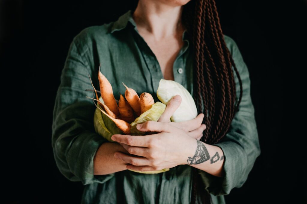 Faceless portrait of vegan woman holding vegetables. Veganism, vegetarianism, plant-based diet
